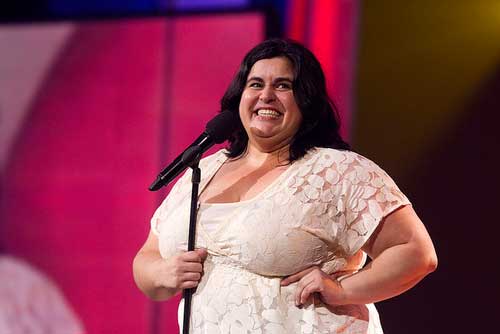 comedian Debra DiGiovanni laughs on stage