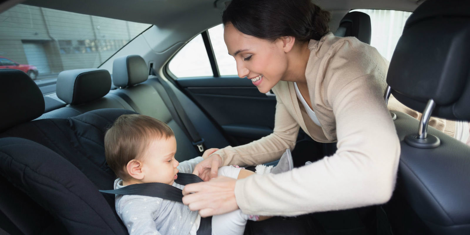 picture-of-mom-securing-baby-in-car-seat