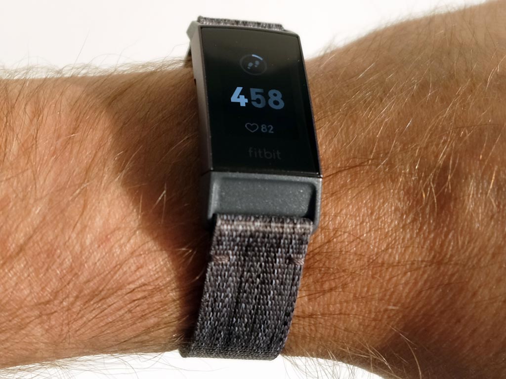 fitbit charge 3 strapped on a persons arm