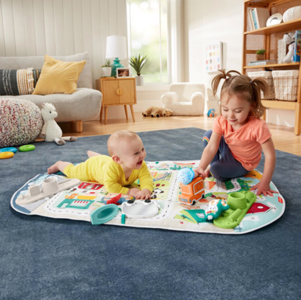 Baby and toddler on the Fisher Price activity mat
