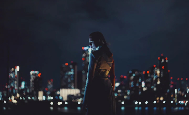 A photo of a woman and a city skyline at night. Provided by Sony