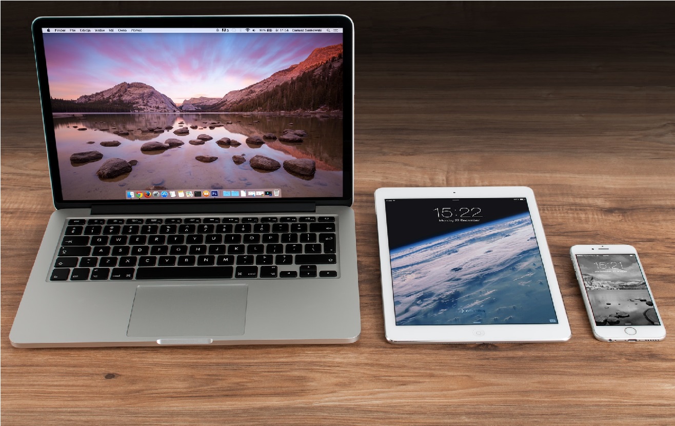 image of a MacBook, iPad, and iPhone in row on a table