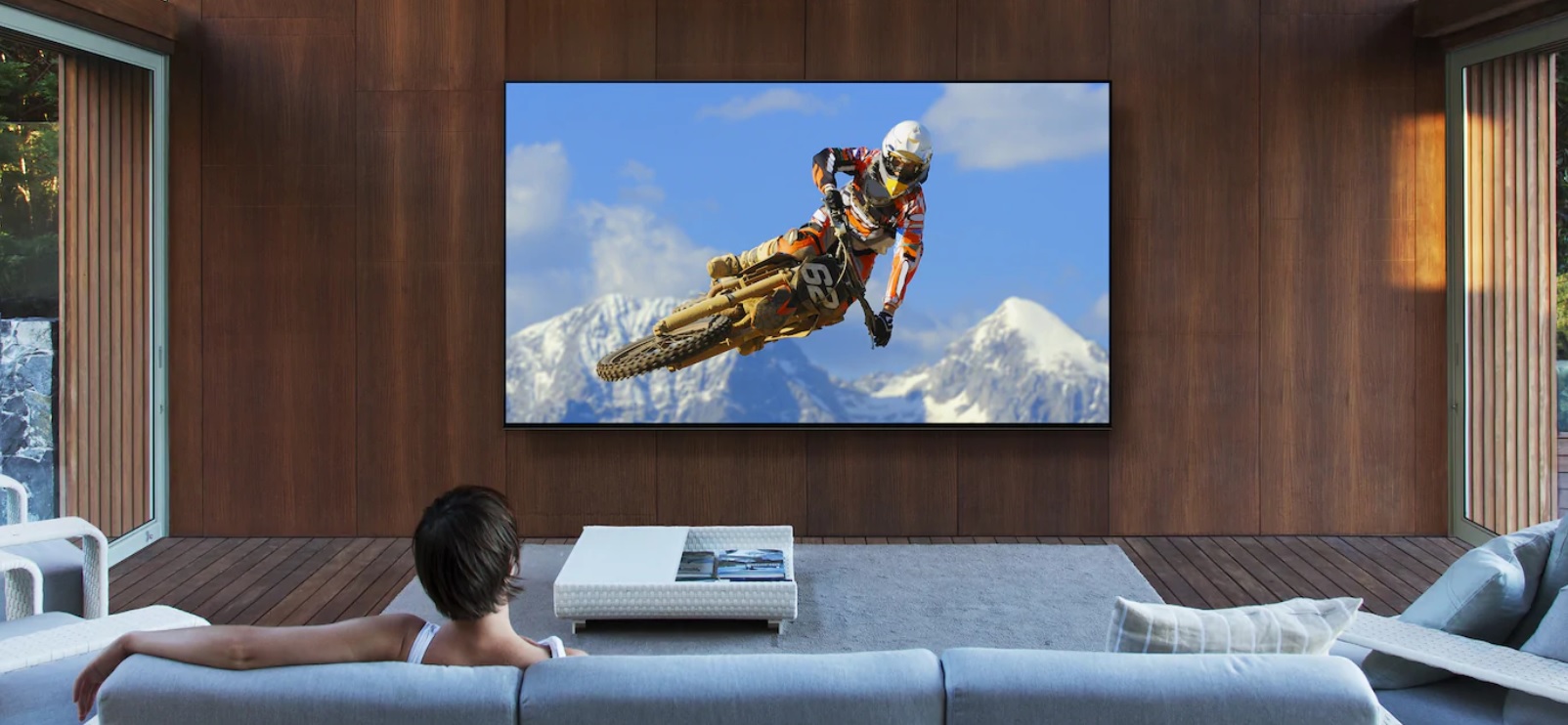 image of a woman on a sofa watching a mountain biker on smart TV