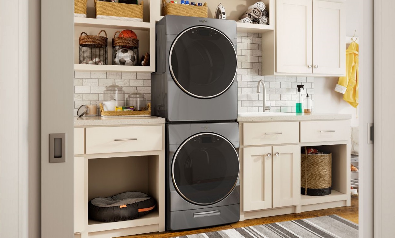 Image of a stacked Whirlpool laundry pair among many storage cabinets