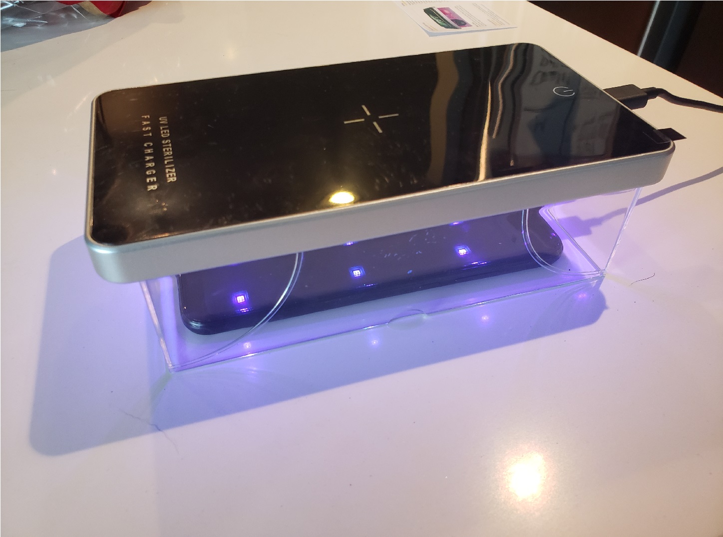 image of the UV sterilizer box placed over a phone and shining UV light on it