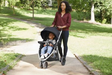 A mother on a walk with her kid in a stroller