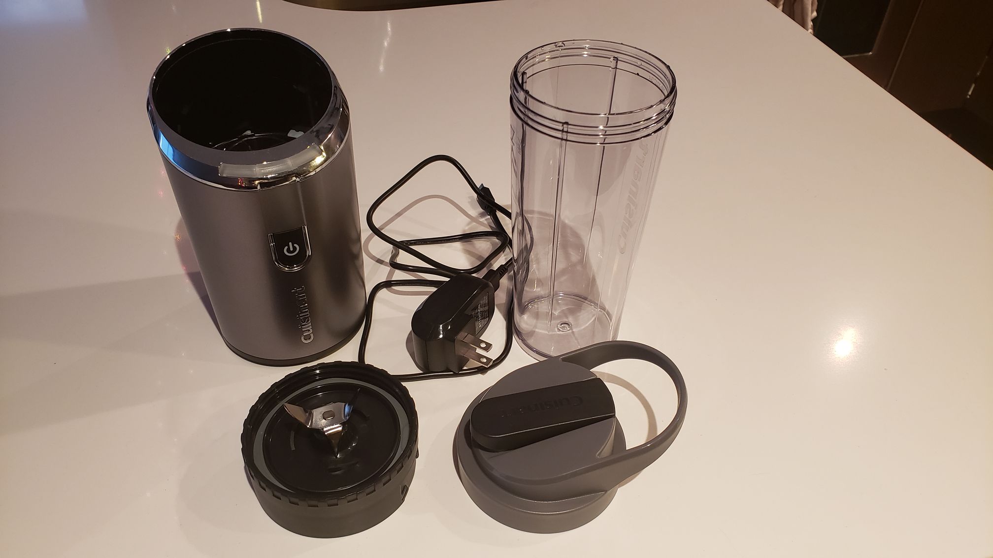 image of all the blender components: base, blades, tumbler, travel lid, and cord