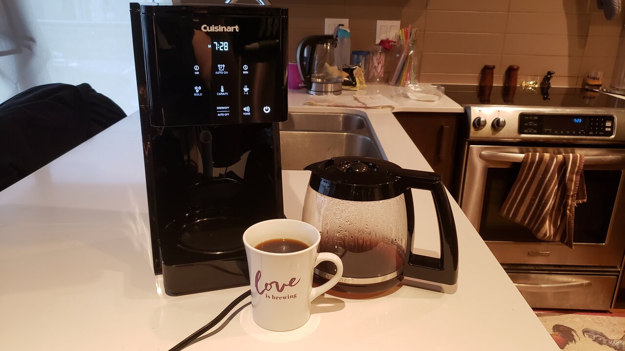 image of the coffee maker next to the carafe and mug of coffee