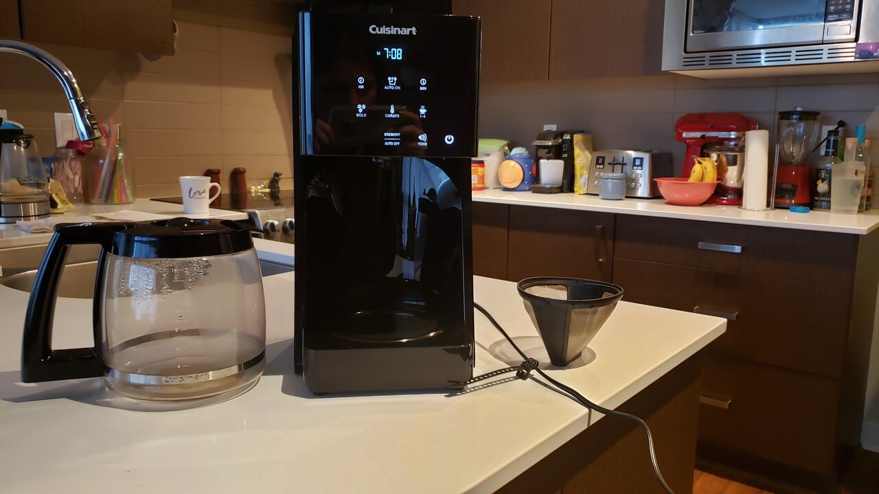 image of the coffee maker next to the carafe and reusable filter