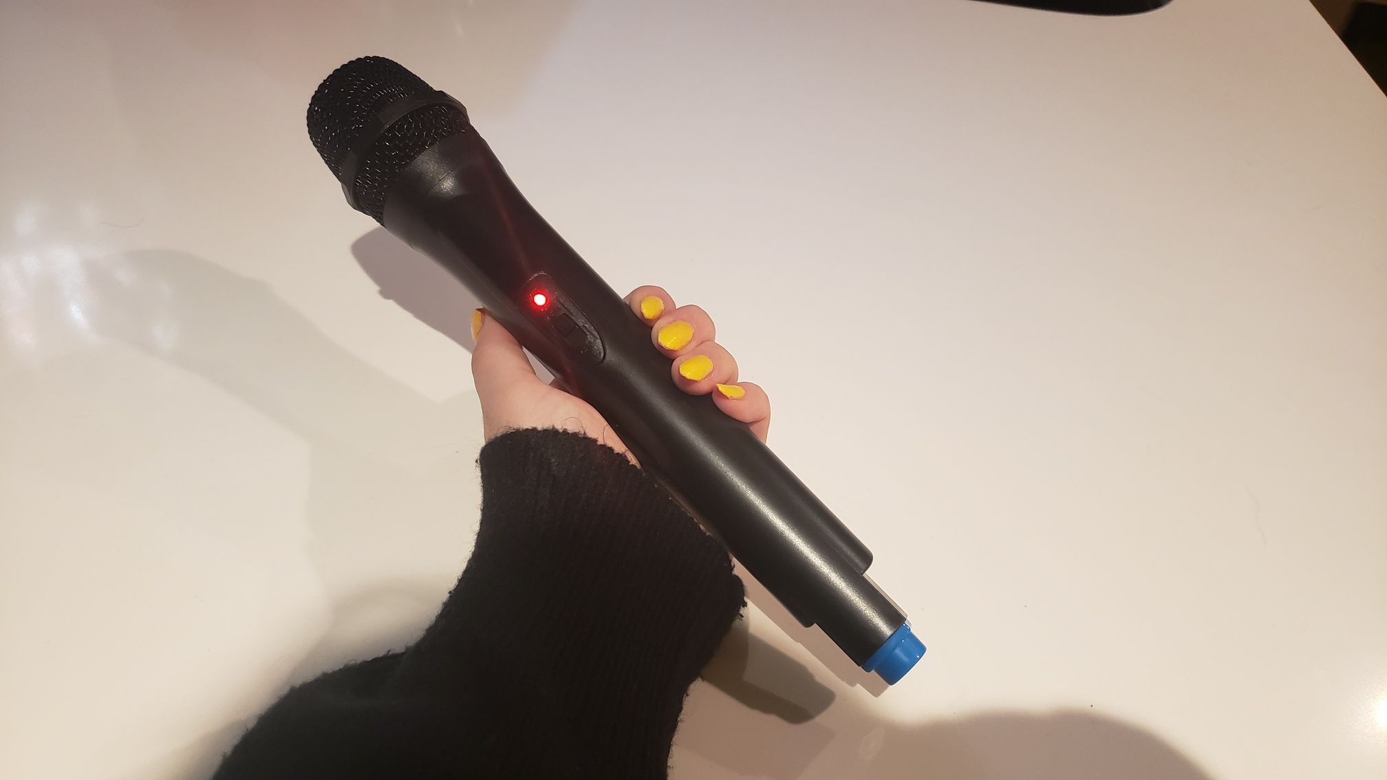 a hand holding the Wireless Add-On Microphone