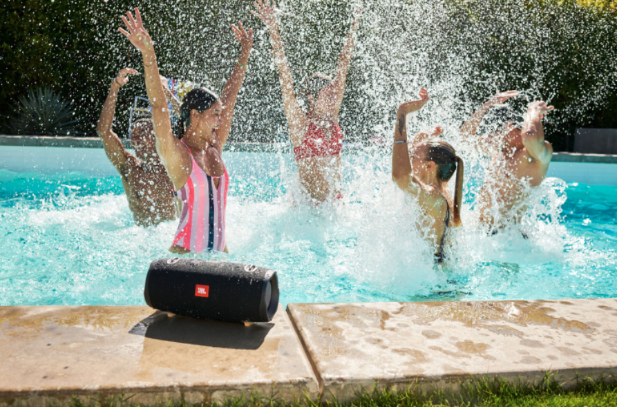 JBL Xtreme portable Bluetooth speaker with people in pool.
