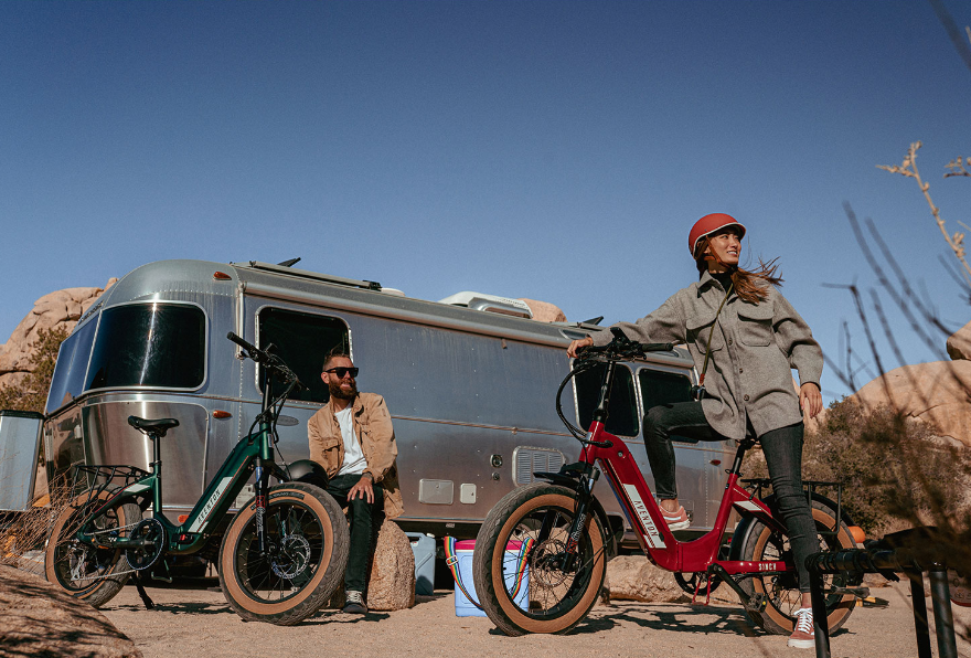 Two people at a trailer with electric bikes.