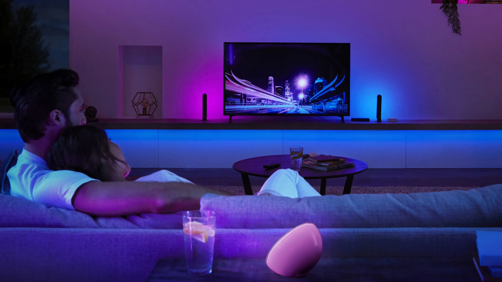 Phillips hue lamps and lightstrips neon ambience with nighttime cityscape display in home theatre