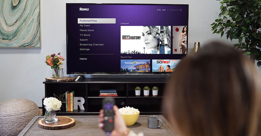 Roku Media streamer and remote showcased on a Smart TV with the Roku feed open