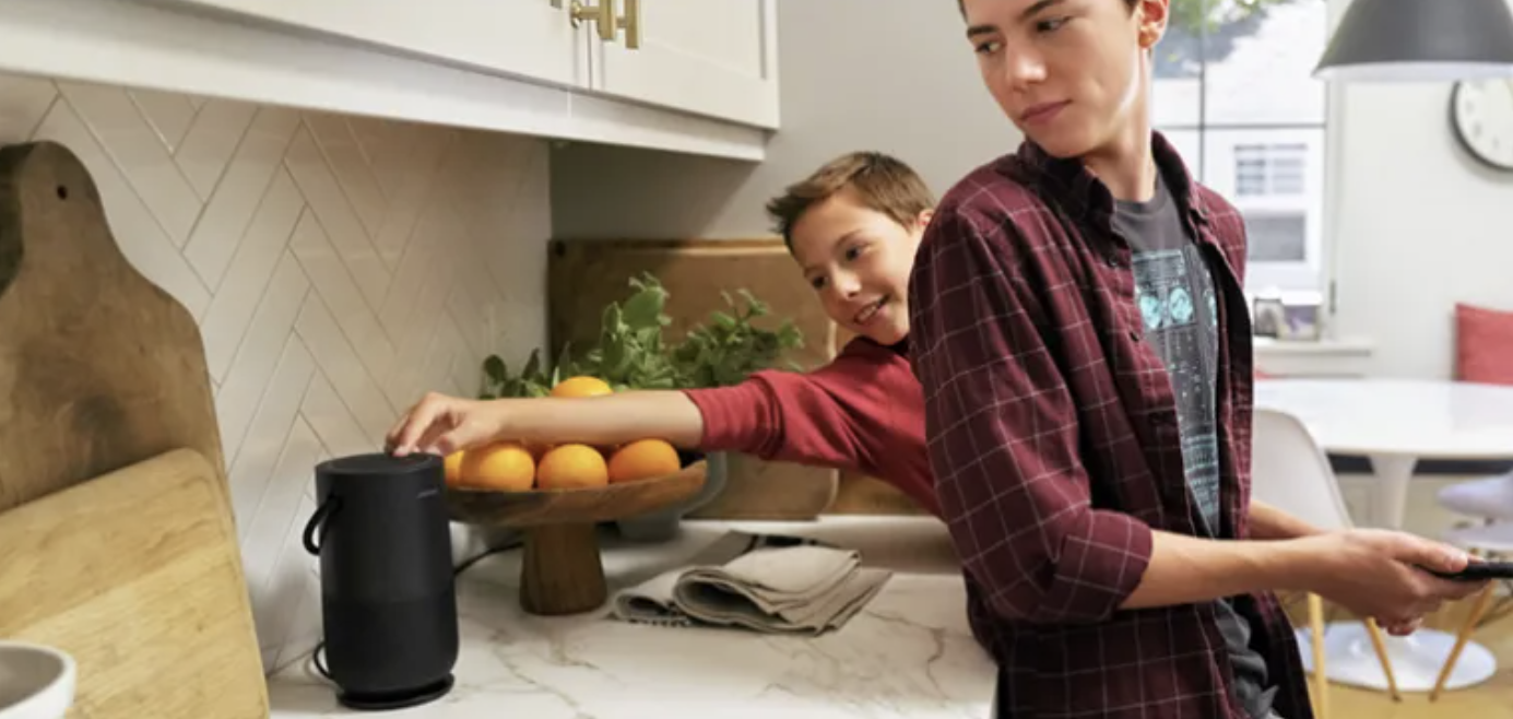 Два подростка на кухне с портативной умной колонкой Bose