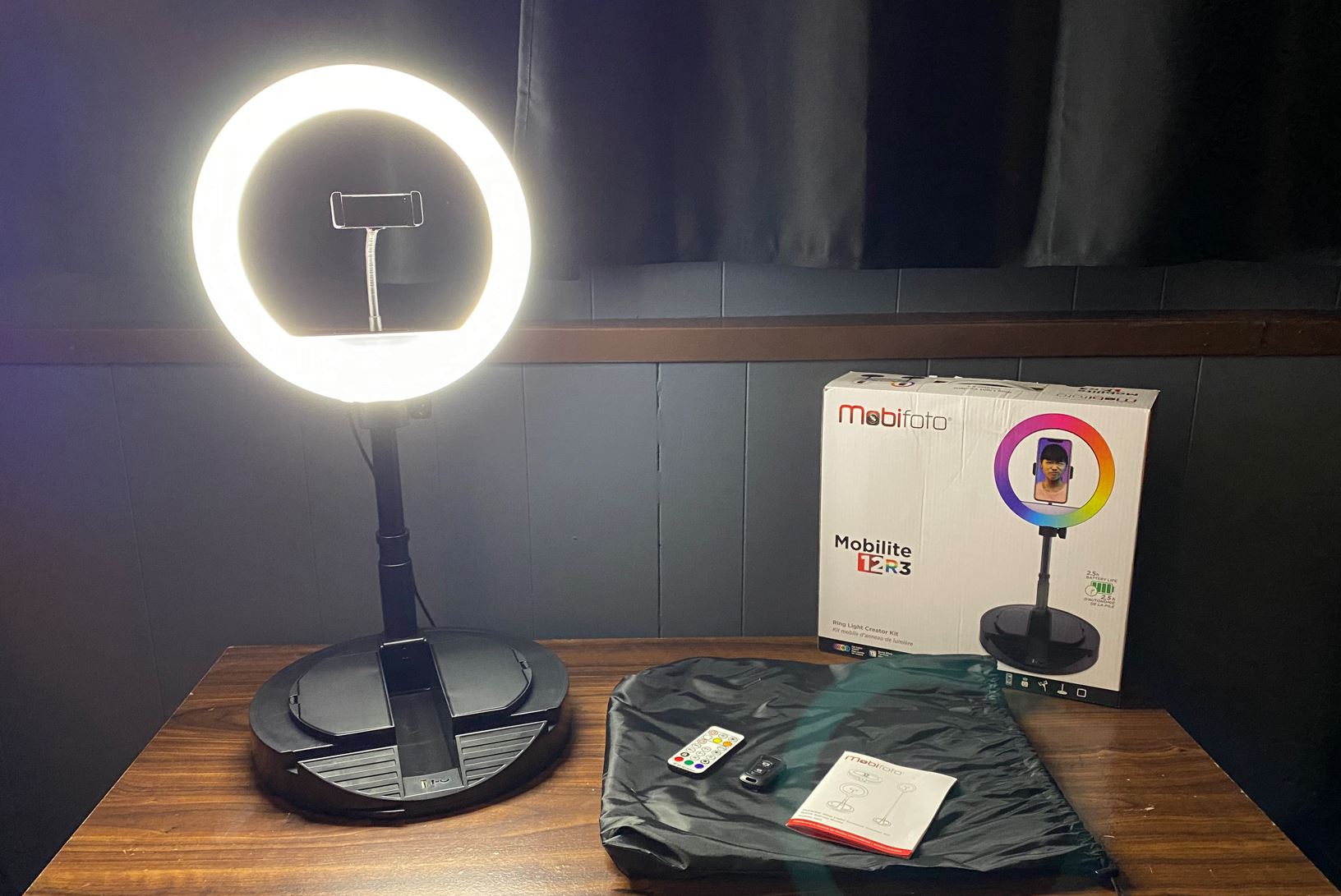 Fully set up Mobifoto ring light with all accessories placed next to it and the box