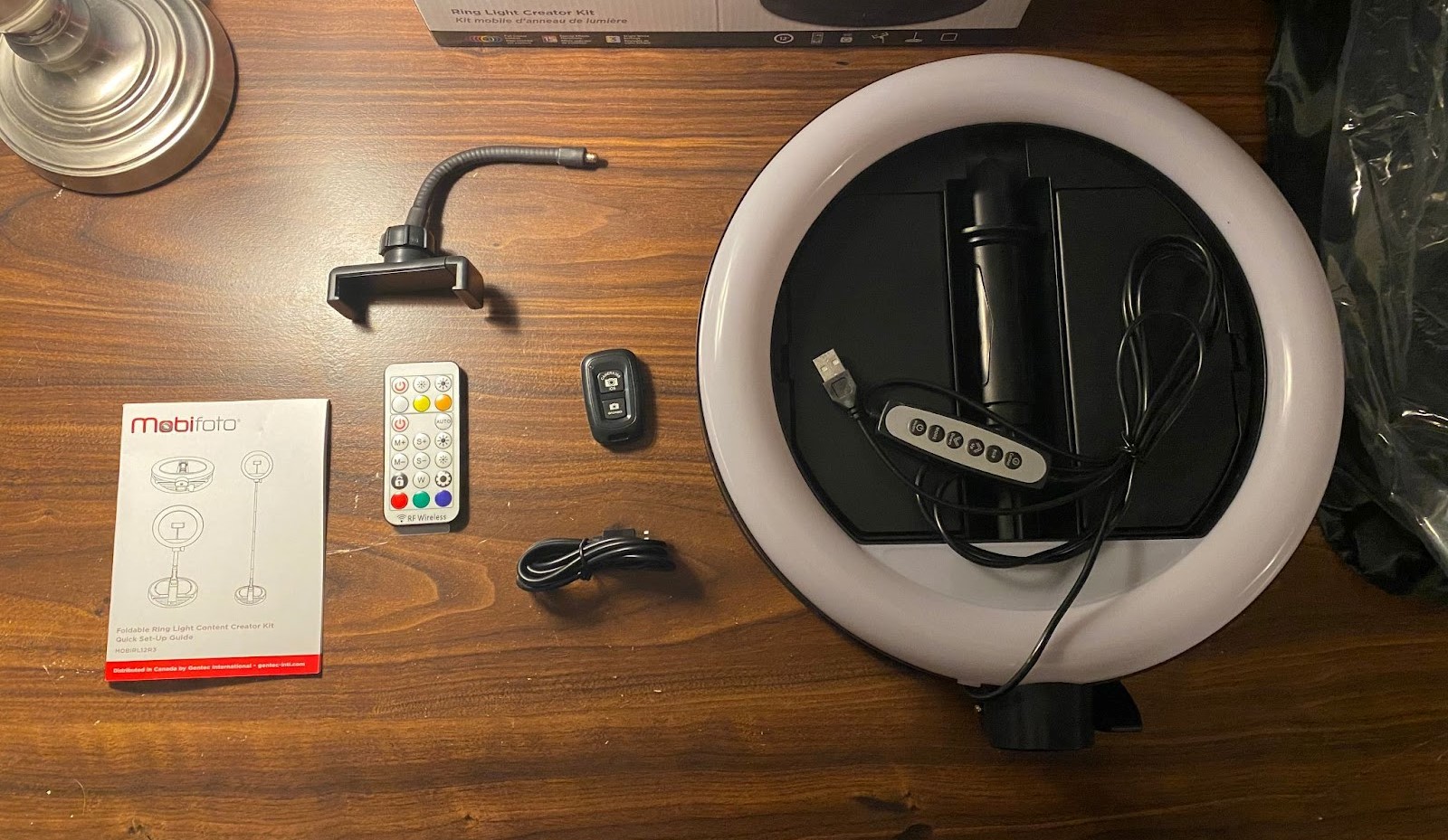 The Mobifoto ring light fully unboxed with the light and it's accessories laid out on a table