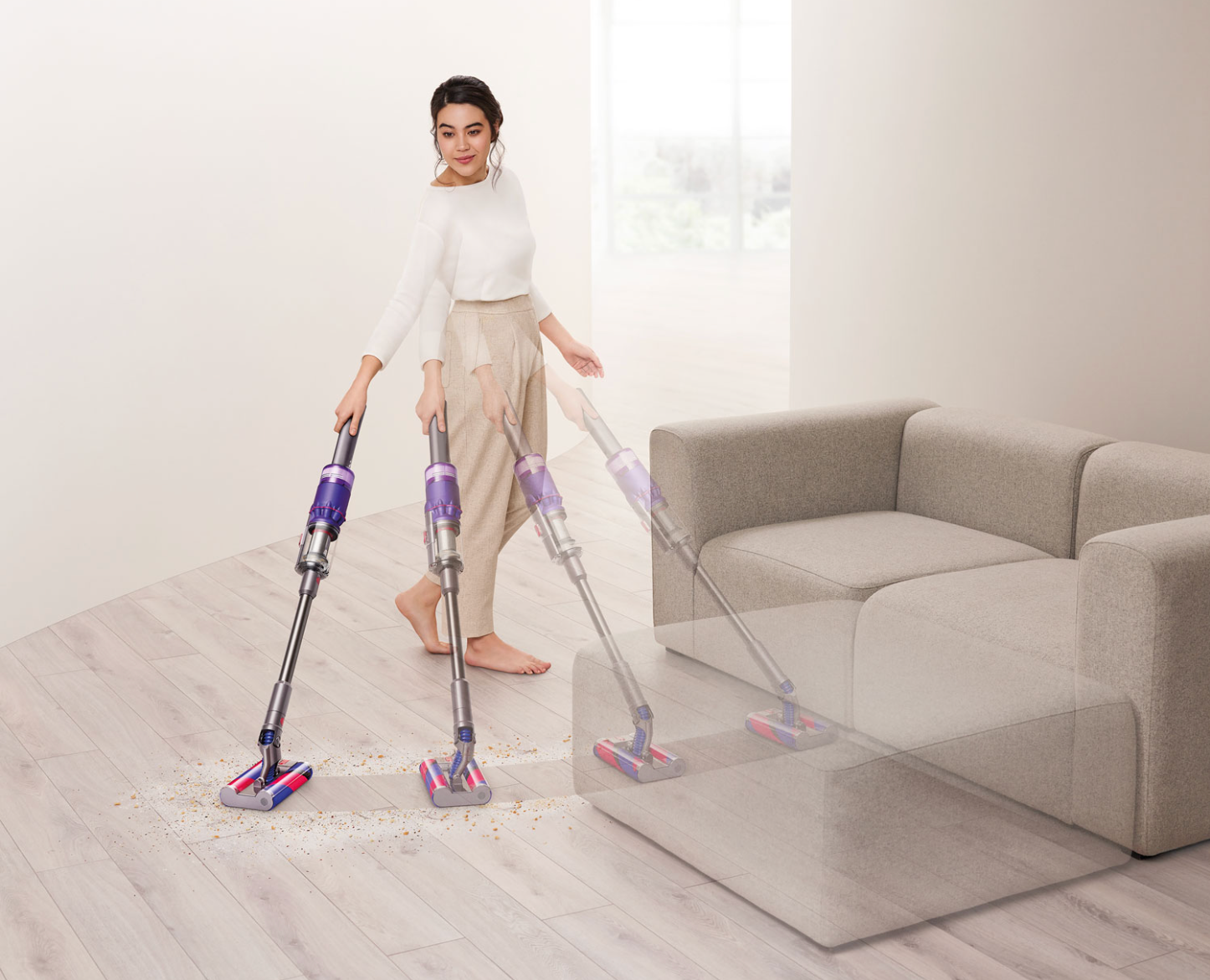 Woman vacuuming with a Dyson cordless vacuum.
