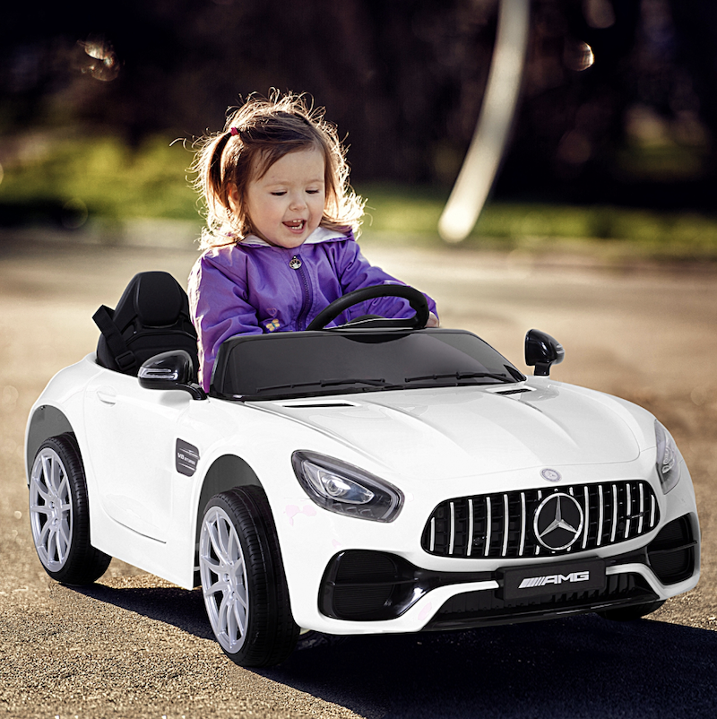 Child in an Aosom ride-on car