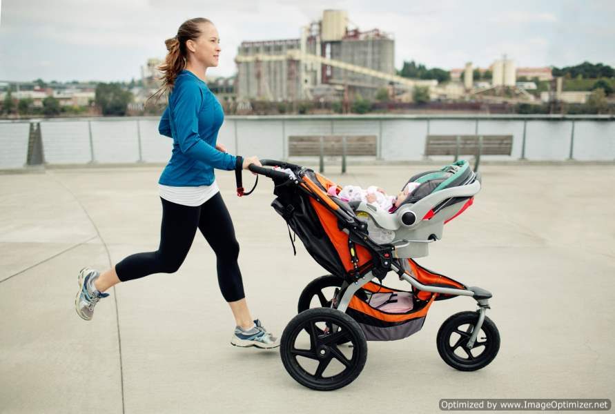 Woman pushing a stroller while going for a jog