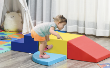 Toddler walking on blocks platform.