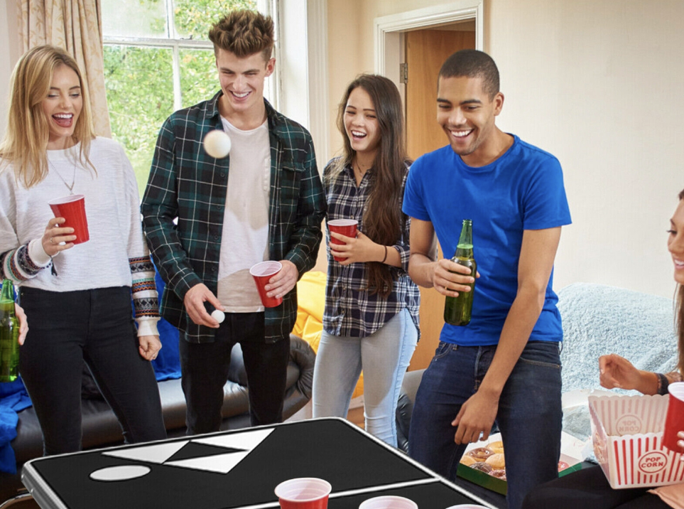 A group of friends playing beer pong.