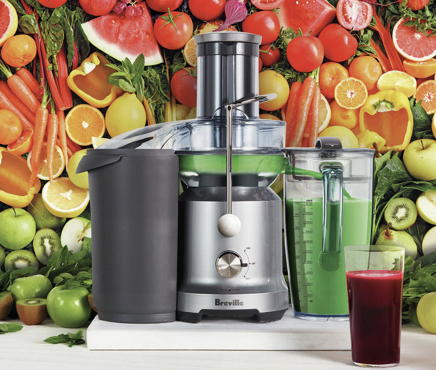 Breville Juice Fountain surrounded by fruits and vegetables in the background.
