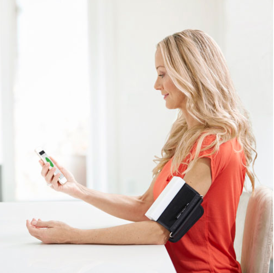 A woman with the Qardio blood pressure monitor on her arm.