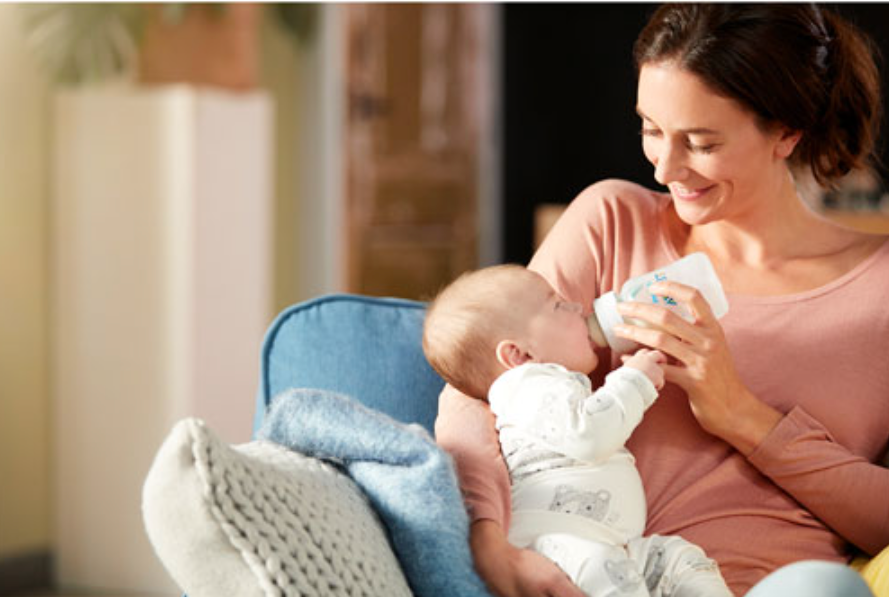 Mom feeding baby with a Philips Avent bottle.
