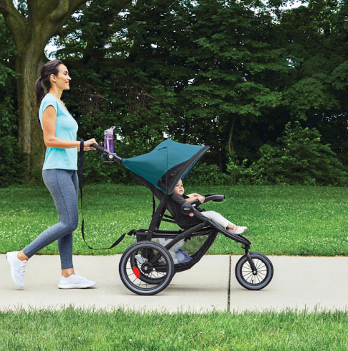 Mom walking with baby in a Snugride stroller.