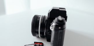 Photo of a camera with some SD cards sitting on a tabel