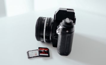 Photo of a camera with some SD cards sitting on a tabel