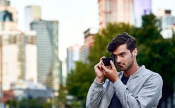 A photo of a photographer in an urban setting shooting with the Sony RX100 VI