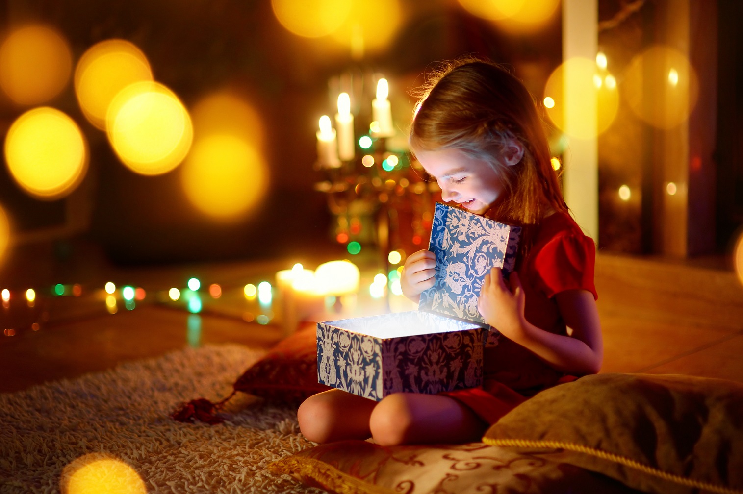 Little girl opening a magical Christmas gift