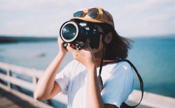 A photo of a woman taking a photograph on a pier