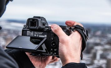 A photographer choosing his file type on the back of his camera