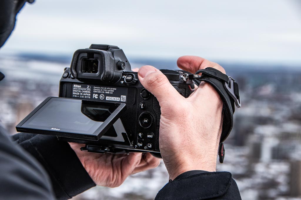 A photographer choosing his file type on the back of his camera