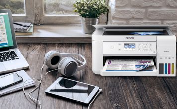 Printer on desk with headphones and notepad