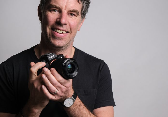 Photographer Justin Morrison holding the Sony a7 III mirrorless camera