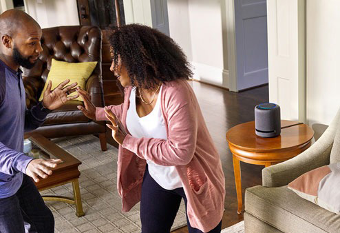 A couple dancing with the Amazon Echo Studio in the background.