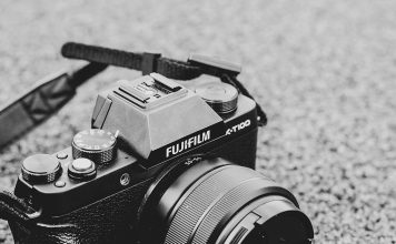 A photo of a mirrorless camera sitting on the ground