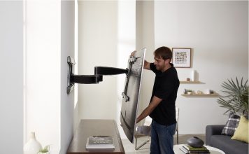 image of man adjusting a mounted TV