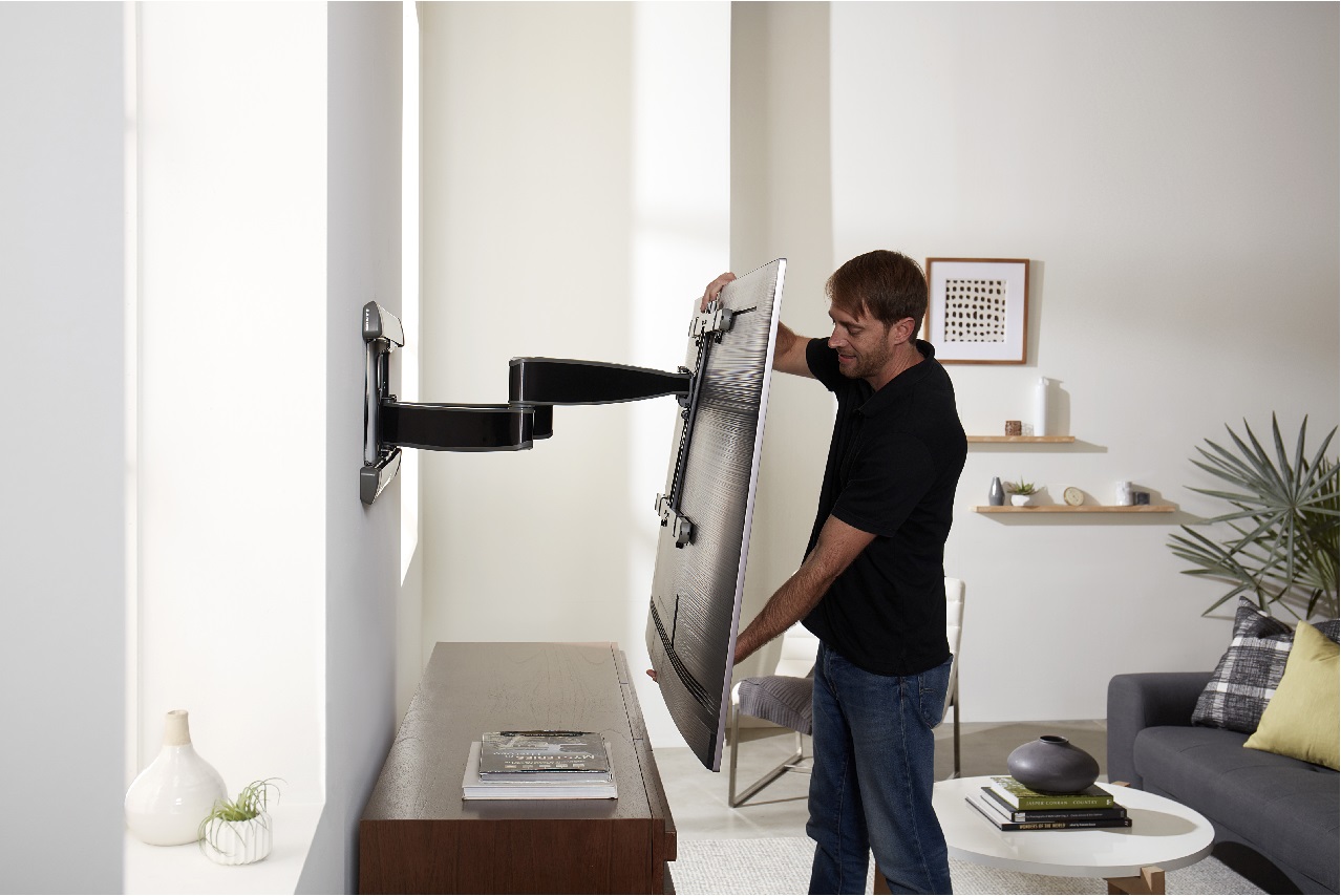 image of man adjusting a mounted TV