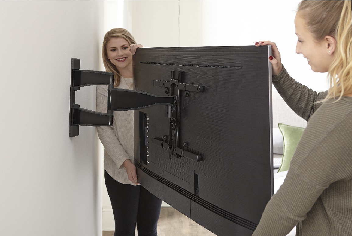 image of two women mounting a TV