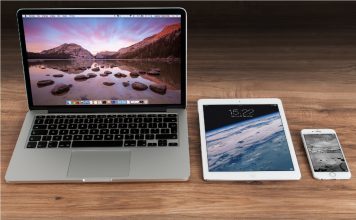 image of a MacBook, iPad, and iPhone in row on a table