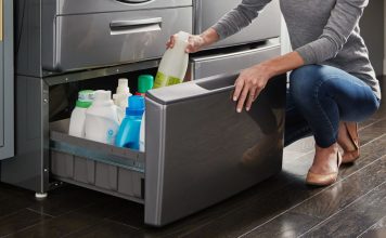 Image of a woman opening a pedestal drawer beneath a washing machine to store cleaning supplies