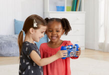 Two kids playing with a VTech Kidizoom camera