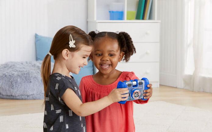 Two kids playing with a VTech Kidizoom camera