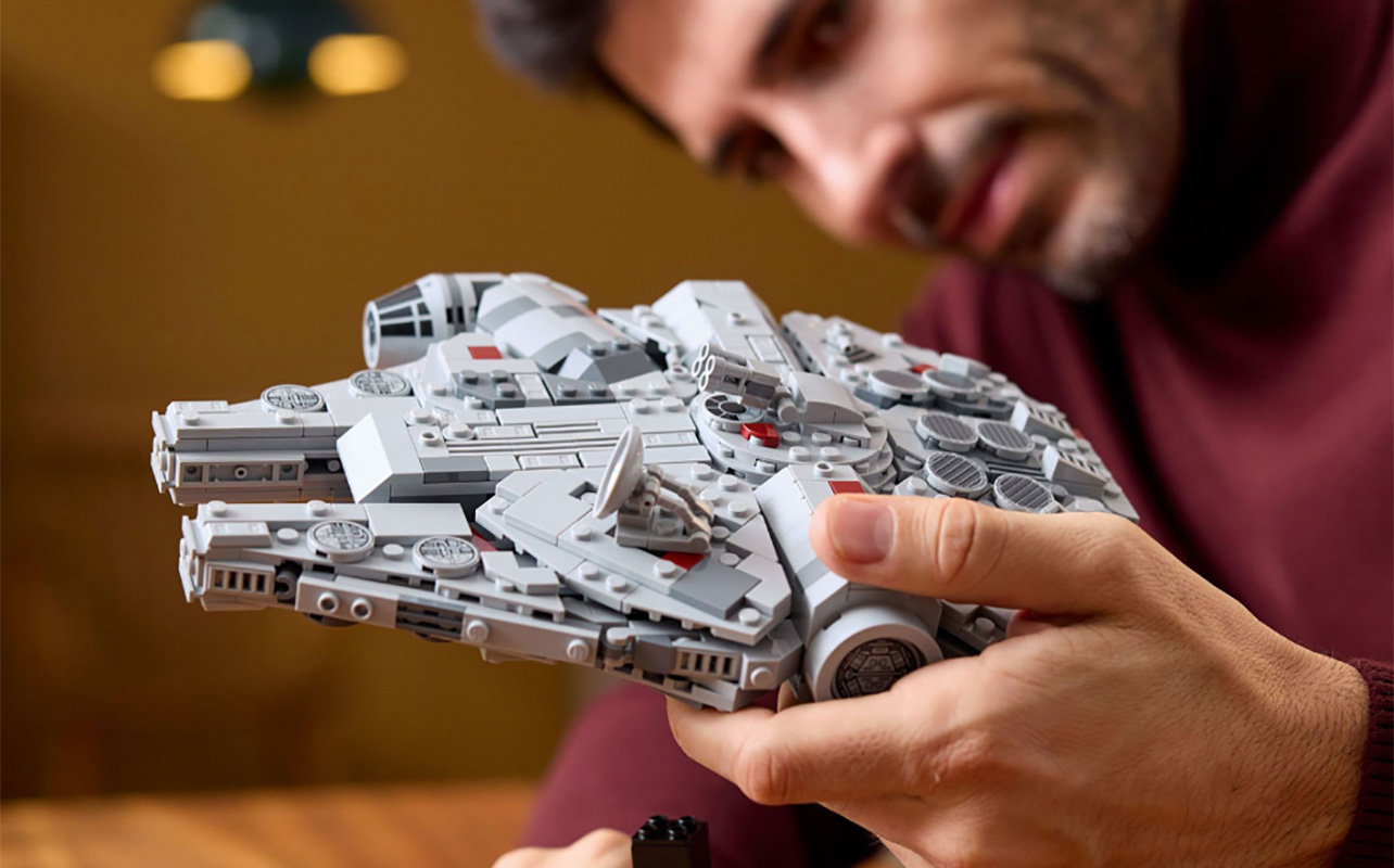 A man holding the Lego Millenium Falcon