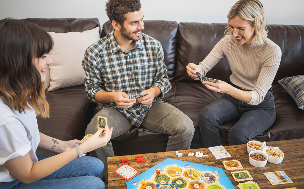 Family playing Settlers of Catan board game